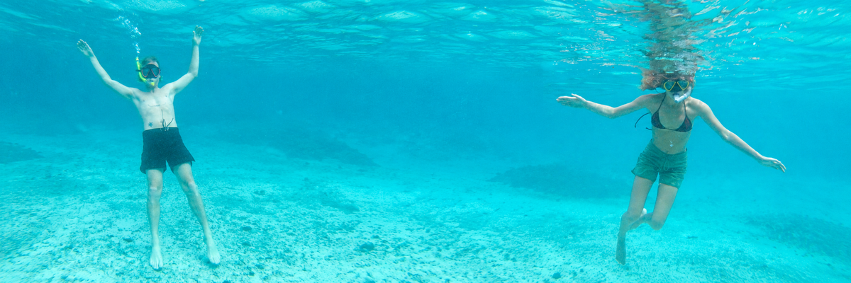 Two snorkellers wearing MARSH boardshorts in turquoise water